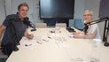 Bernd Stampfl und Angelika Ludwig sitzen an einem Tisch mit Microphonen und lächeln in die Kamera.